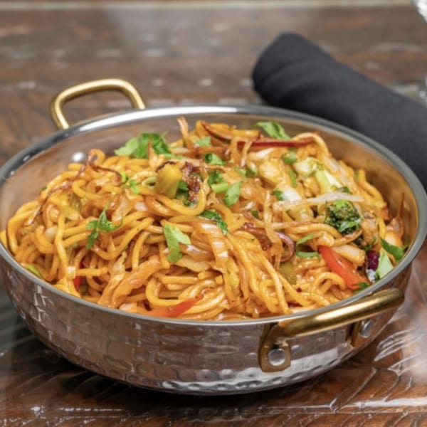 Himalayan Doko's Indian noodles with vegetables and herbs in a hammered metal bowl.