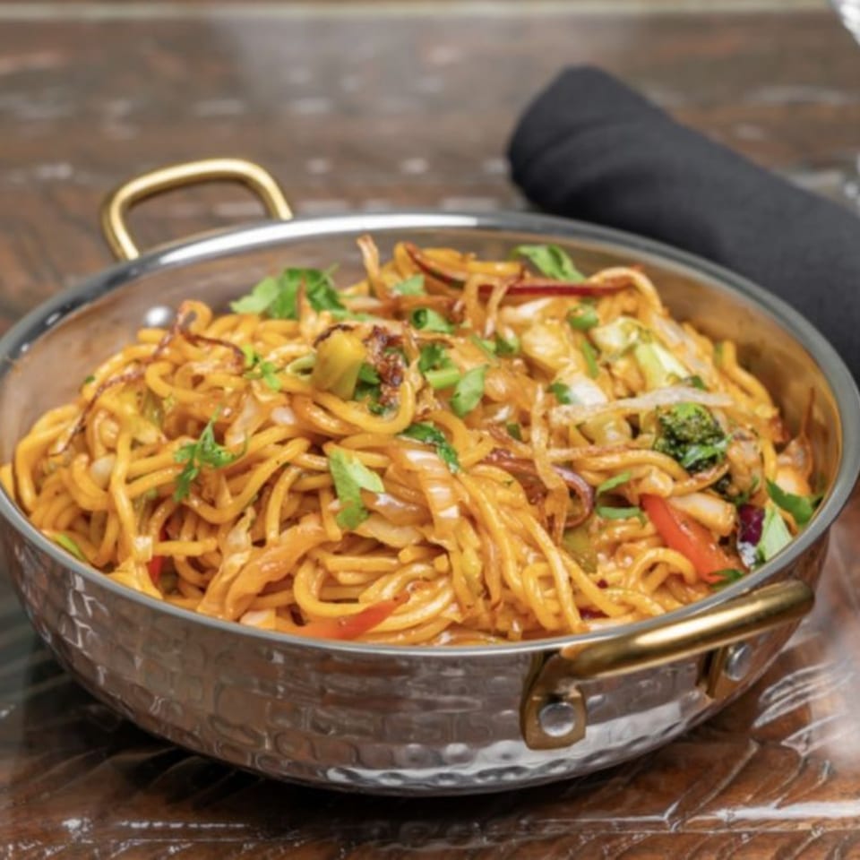 Himalayan Doko's Indian noodles with vegetables and herbs in a hammered metal bowl.