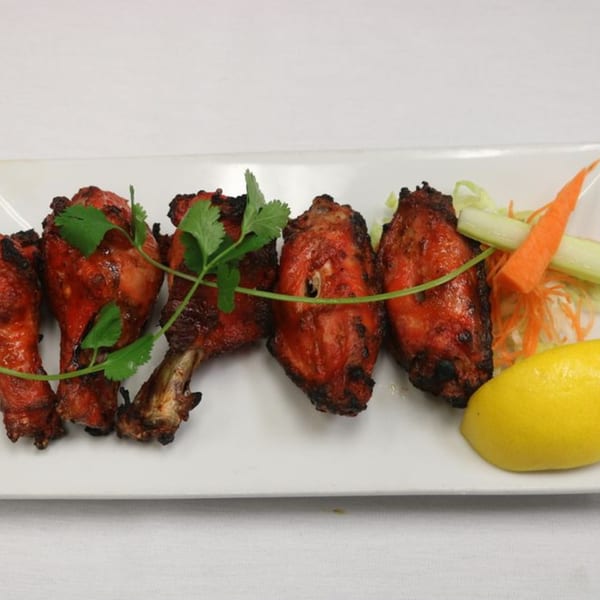 Himalayan Doko's Indian Tandoori Chicken, garnished with cilantro, lemon, and shredded vegetables.