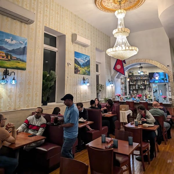Diners seated at tables and booths in the Himalayan Doko restaurant, with a bar in the background.