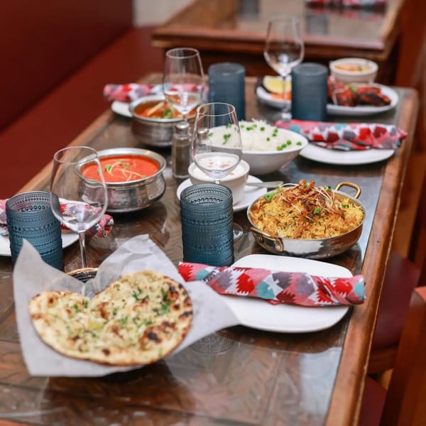A table set with various Indian dishes, including naan, curries, and rice, at Himalayan Doko.